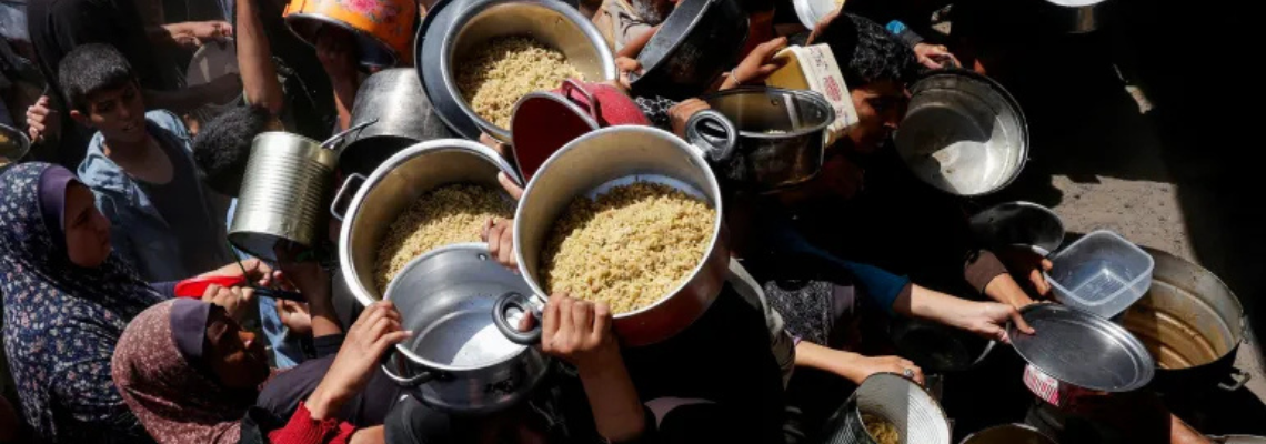Palestinians receive food cooked by a charity kitchen