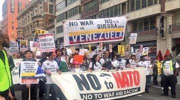 A protester holding a placard saying U.S. war machine: real threat to  peace at a rally against war with Russia sponsored by multiple groups  including CODEPINK: Women for Peace, Black Alliance for