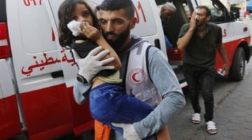 A child is carried from an ambulance after a bombing